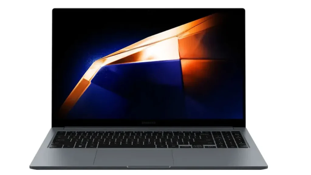 Notebook premium Samsung Galaxy Book4 de cor cinza escuro aberto de frente, destacando suas bordas de tela ultra finas, painel IPS antirreflexo com papel de parede geométrico em tons de dourado e azul, e trackpad amplo centralizado.