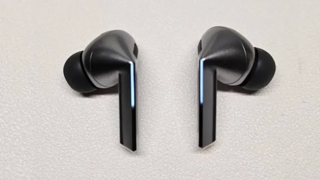 Par de fones Samsung Galaxy Buds 3 Pro exibindo as faixas de luz LED verticais (Blade Lights) acesas em ambiente escuro.